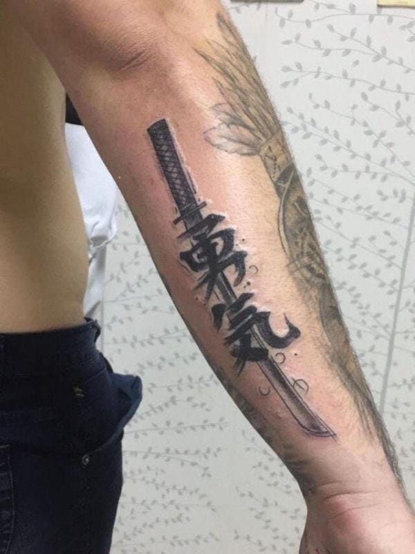 Tattoo chữ Hán với thanh kiếm ở giữ đặt ngay trên cánh tay tạo ra tác phẩm đầy tính nghệ thuật lại không kém phần mạnh mẽ