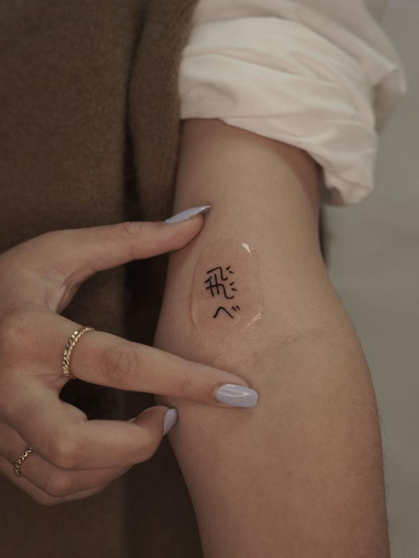 Hình xăm chữ Nhật "飛べ" (Tobe) với ý nghĩa "Bay đi". Mẫu tattoo với đường nét mảnh khảnh, thể hiện đúng tinh thần của từng câu chữ với mong muốn chủ sở hữu có thể bay thật xa, làm những điều mình mong muốn vì chính bản thân mình