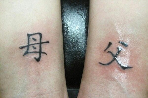 Hình xăm “Phụ Mẫu” (父母) như sợi chỉ đỏ nối con với đấng sinh thành, dù cách xa vẫn chẳng đứt rời.