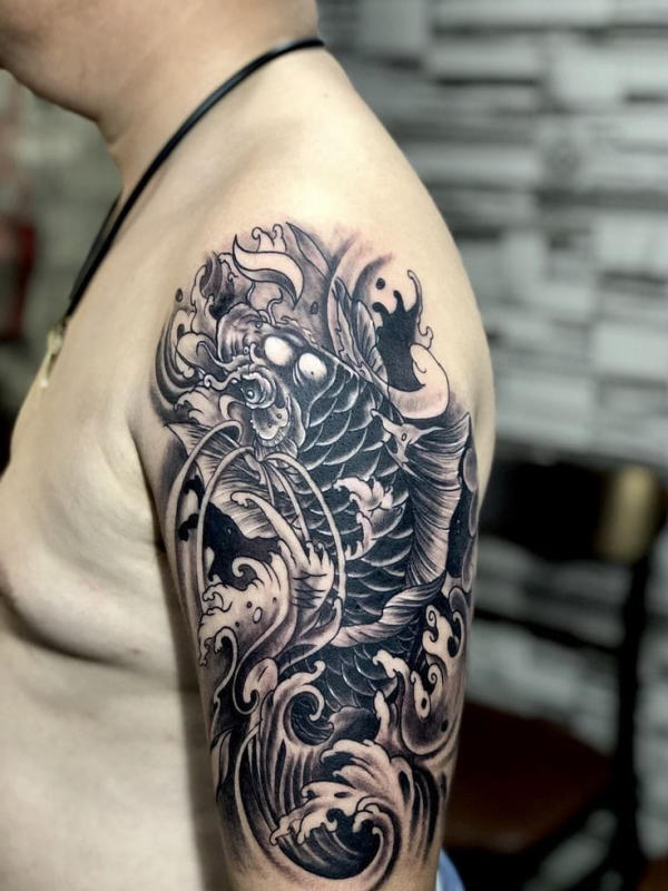 Mẫu tattoo cá chép đen trắng khắc họa vẻ đẹp thuần khiết, mạnh mẽ. Sự tương phản sắc sảo giữa hai màu đen trắng tôn lên từng đường nét uyển chuyển của thân cá