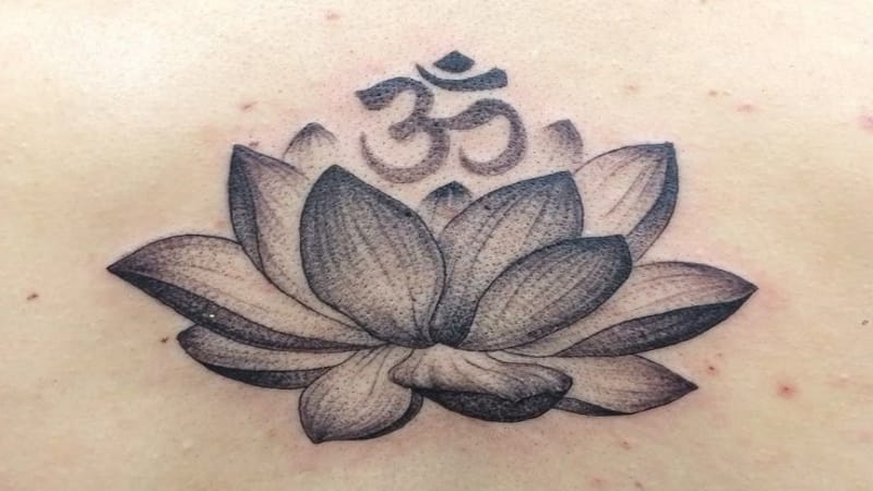 Sự tương phản giữa nét mạnh mẽ của chữ Nhẫn và vẻ mềm mại của hoa tạo nên một tổng thể hài hòa, cân bằng